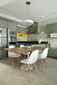 A mesa de jantar neste loft de 67m² em madeira está acoplada à bancada da cozinha e esquenta o ambiente.