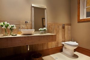 Lavabo rústico com lambri e bancada em madeira de demolição.