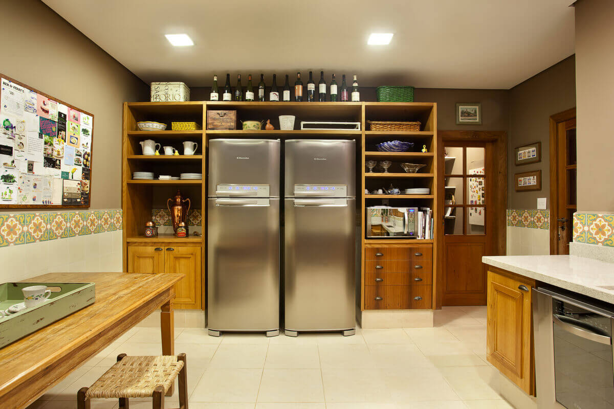 Cozinha rústica com nichos abertos em torno das geladeiras.