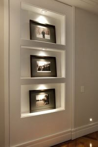 Esta estante embutida na parede com nichos para fotografias, é também uma porta para um quarto secreto.