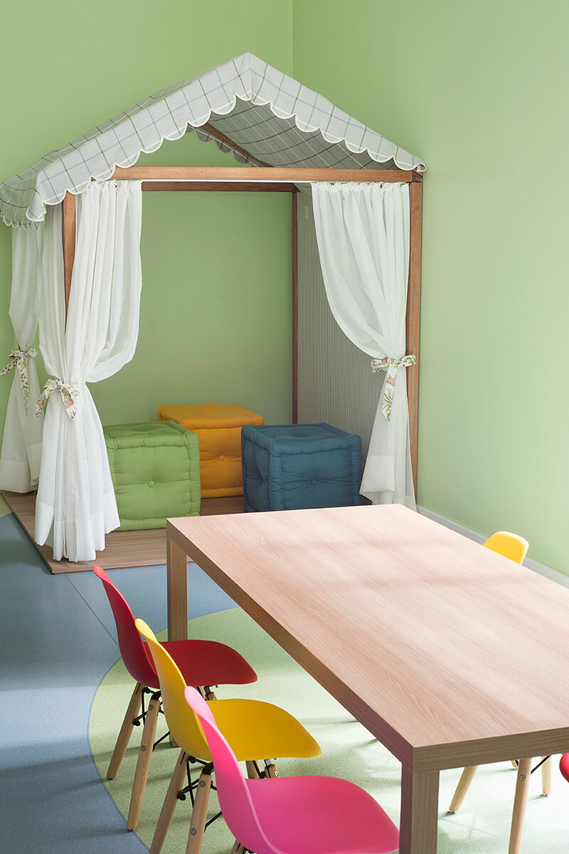brinquedoteca colorida, casinha com estrutura de madeira, puffs coloridos,mesa em madeira com cadeiras eames infantil coloridas