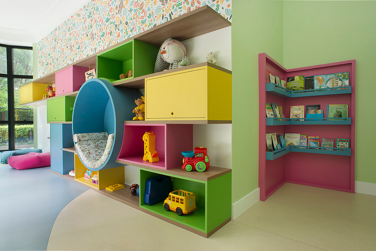 brinquedoteca colorida com nichos abertos e fechados,espaço para leitura, estante para livros