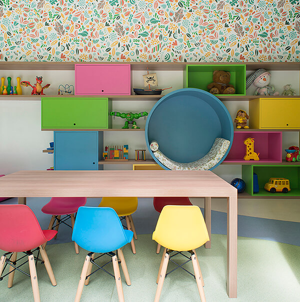brinquedoteca colorida, casinha com estrutura de madeira, puffs coloridos,mesa em madeira com cadeiras eames infantil coloridas