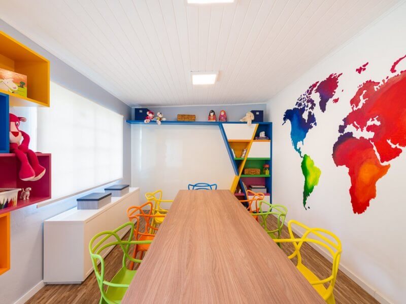 sala de estudos com marcenaria colorida e mapa mundi pintado na parede