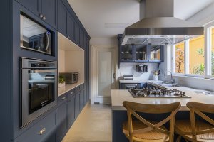 cozinha provençal com armarios azuis e tampo branco e piso de concreto