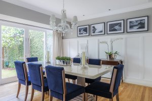 sala de jantar com toques classicos, cadeira azul marinho, boiserie e fotografias do rio de janeiro e preto e branco