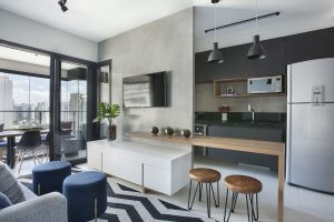 sala e cozinha integradas com painsel de Tv em cimento queimado